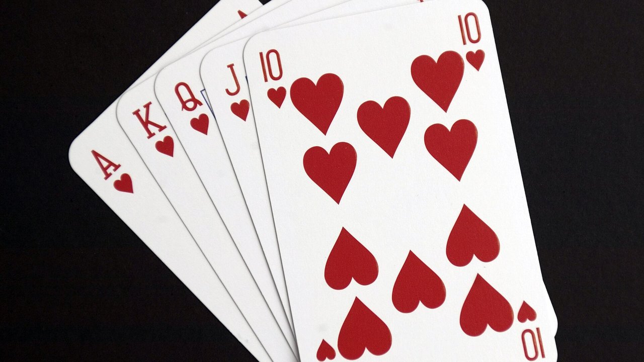 A fanned hand of playing cards showing a royal flush in hearts, ace to ten, against a black background